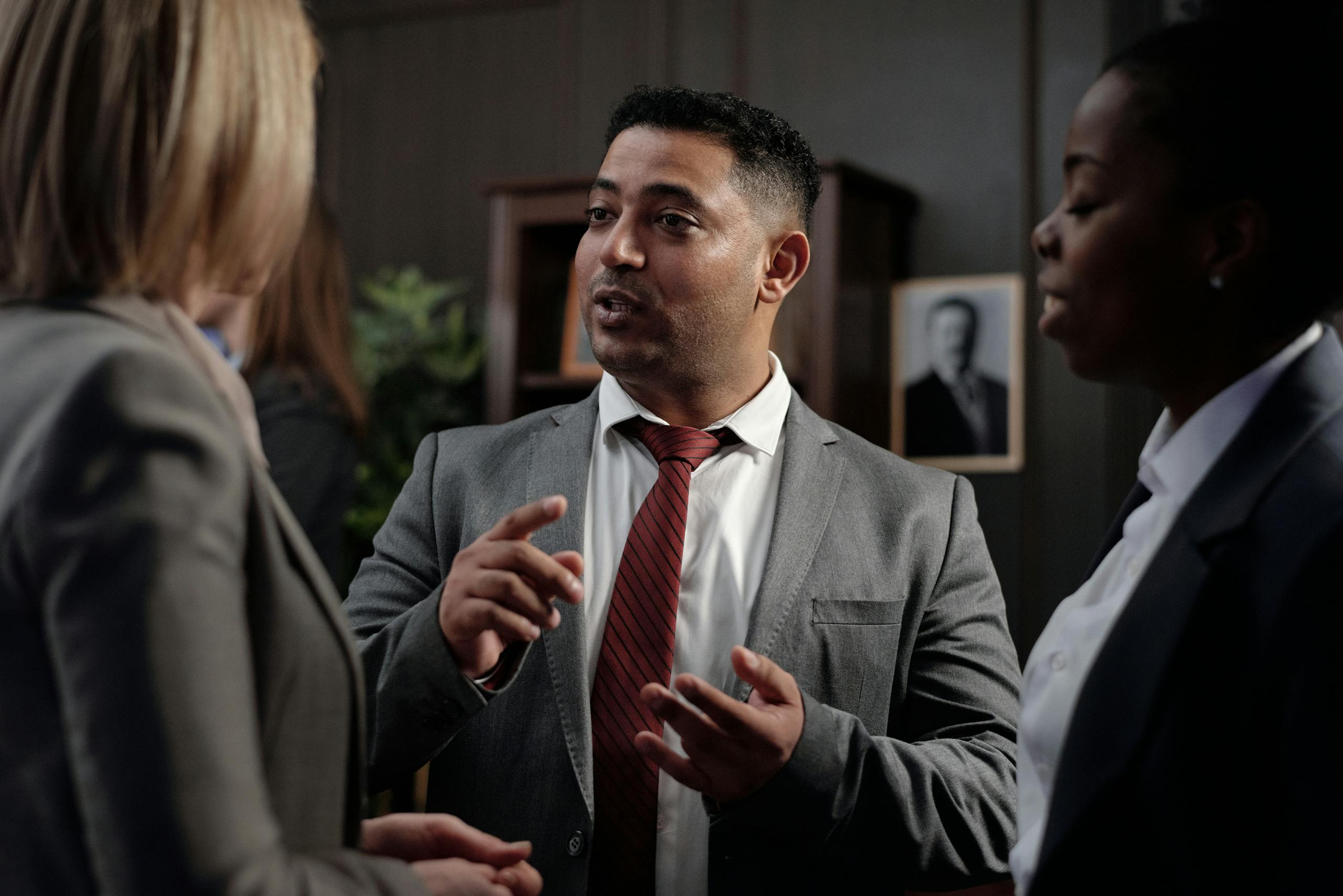 Diverse group of business professionals in suits having an engaging discussion in an office setting.
